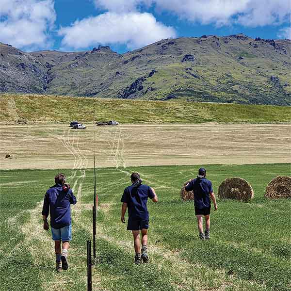 Precise Fencing, Central Otago fencing contractors, walking along a fence line with mountain range in the background